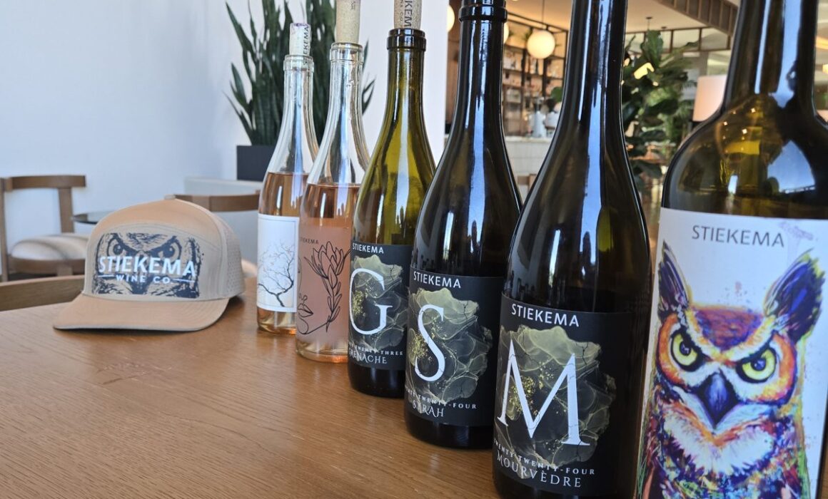 Stiekema Wine Co. lineup of white, rosé, Grenache, Syrah, Mourvèdre and GSM bottles with a Stiekema hat